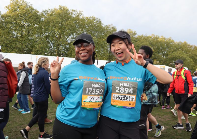 Two women smiling at camera in running kit